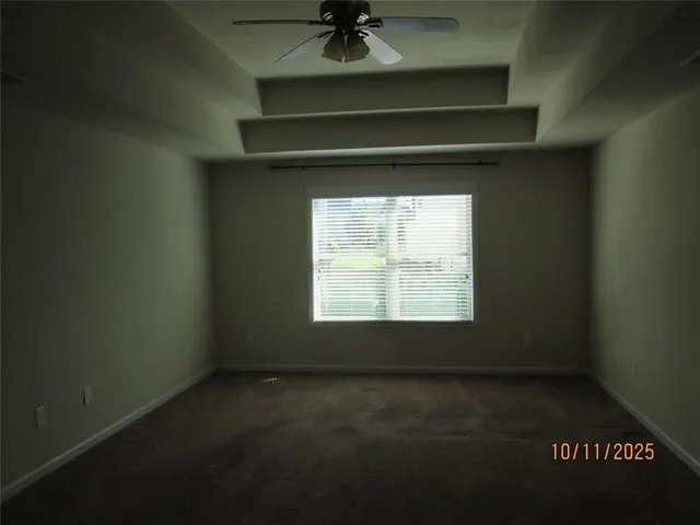 a view of brick house with a large window and potted plants