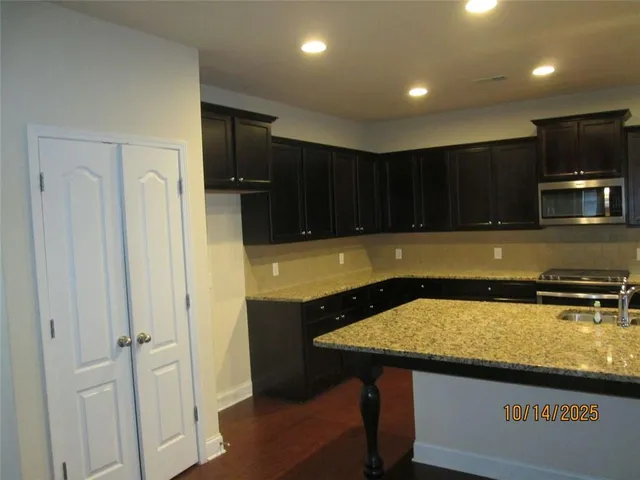 a kitchen with a sink a microwave a refrigerator and cabinets