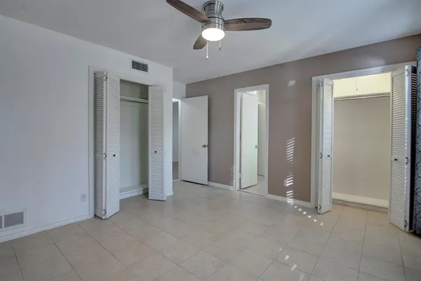 an empty room with windows and cabinet