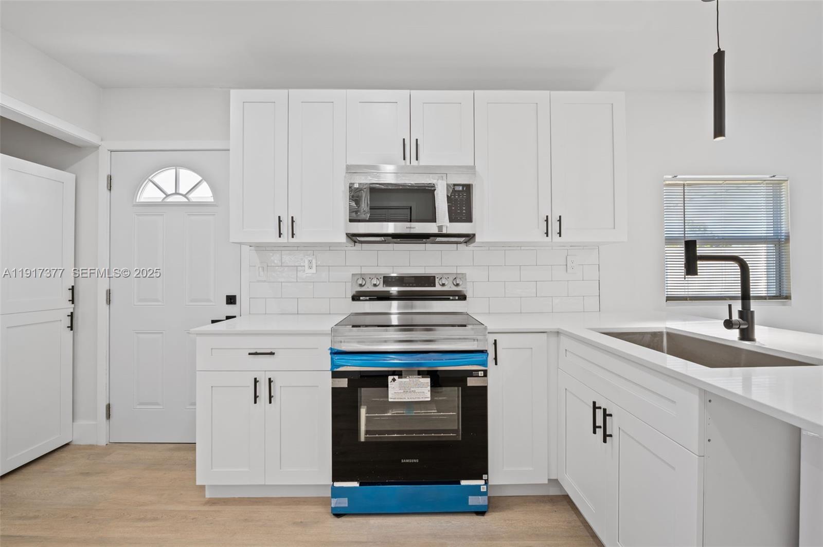 1844 Northwest 67th Street Miami, FL 33147 - Photo 12 of 27 a kitchen with granite countertop a stove and a sink