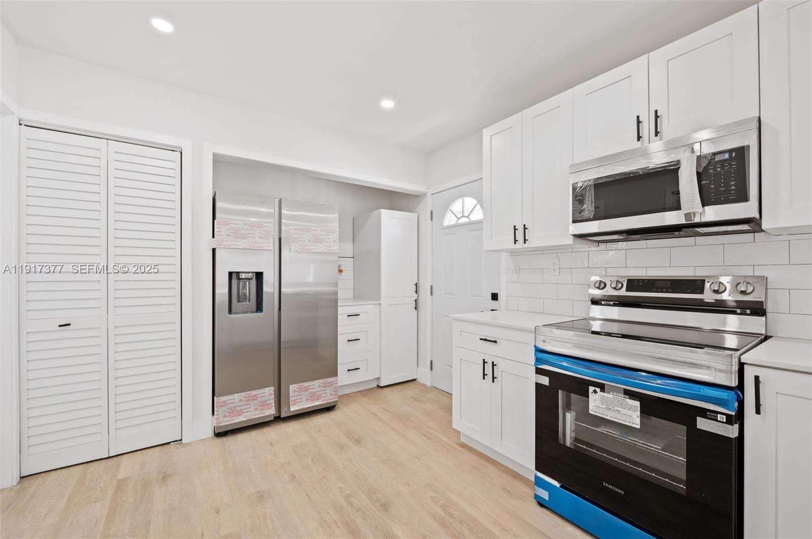 1844 Northwest 67th Street Miami, FL 33147 - Photo 13 of 27 a kitchen with stainless steel appliances a stove microwave and refrigerator