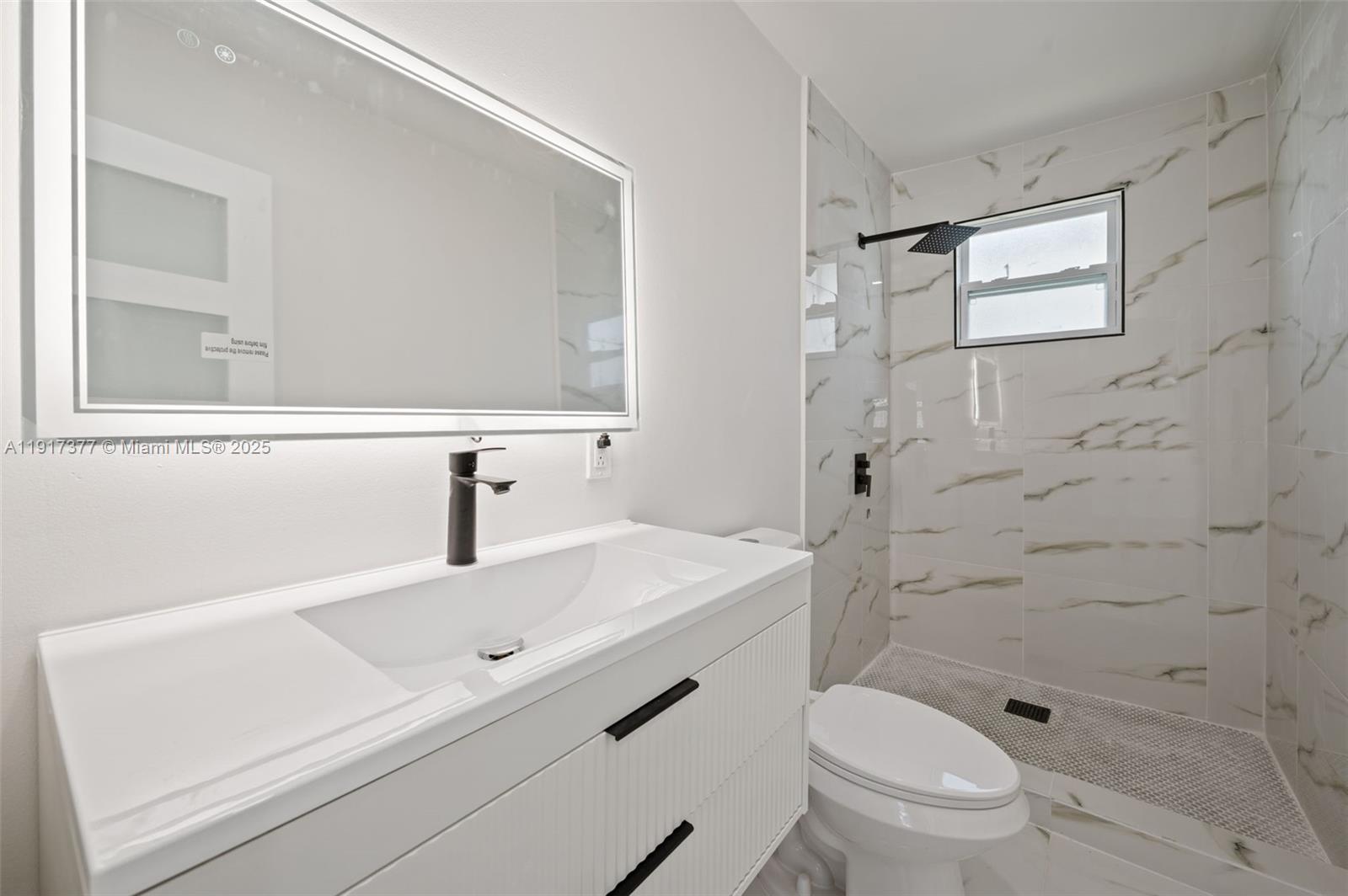 1844 Northwest 67th Street Miami, FL 33147 - Photo 18 of 27 a bathroom with a sink a toilet and shower