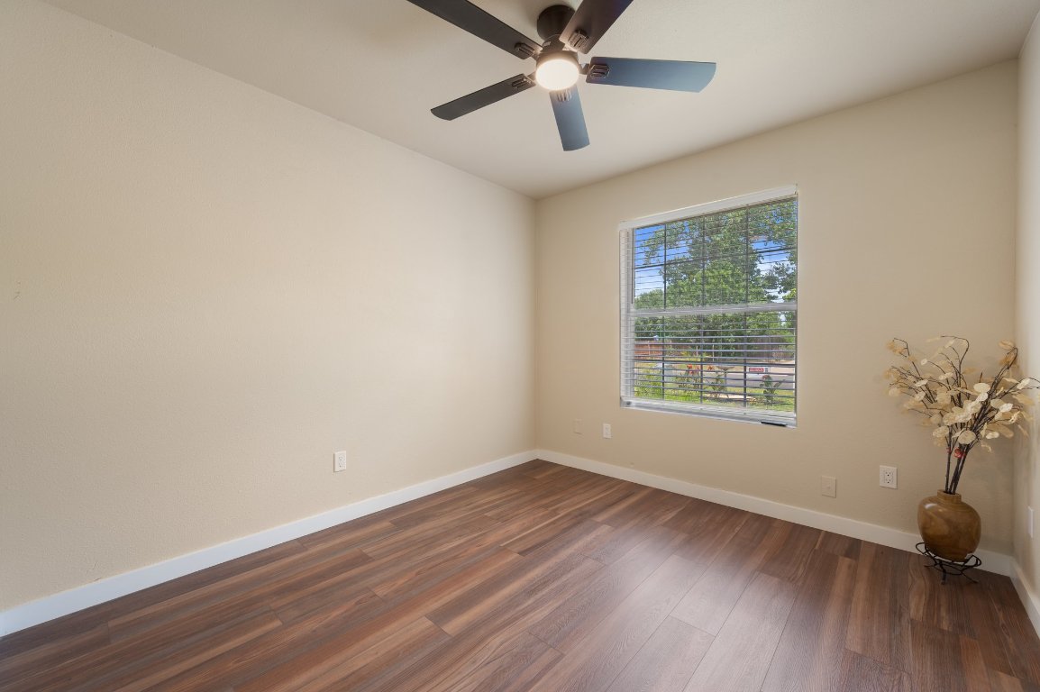 206 Jan Lane Georgetown, TX 78626 - Photo 15 of 23 an empty room with wooden floor chandelier fan and windows