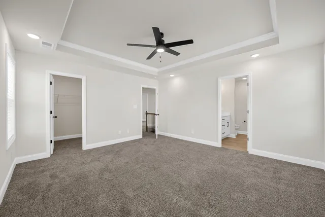 an empty room with closet and a ceiling fan