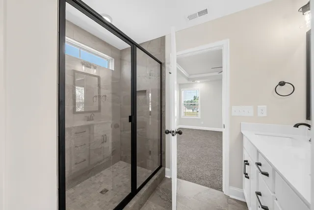 a bathroom with a shower sink and mirror