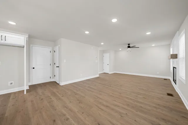 a view of empty room with wooden floor