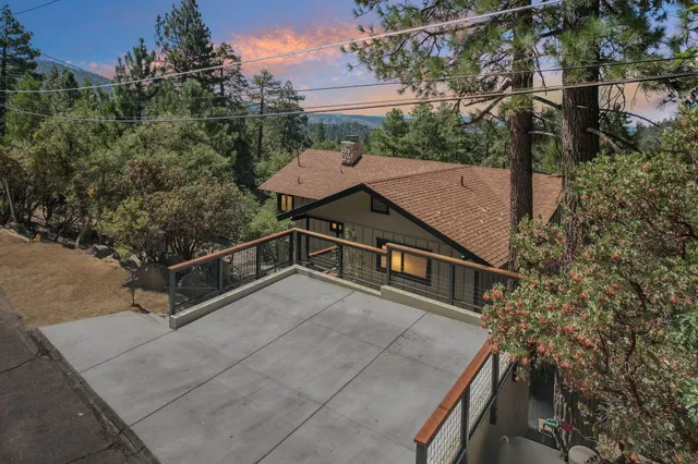 a front view of a house with large trees