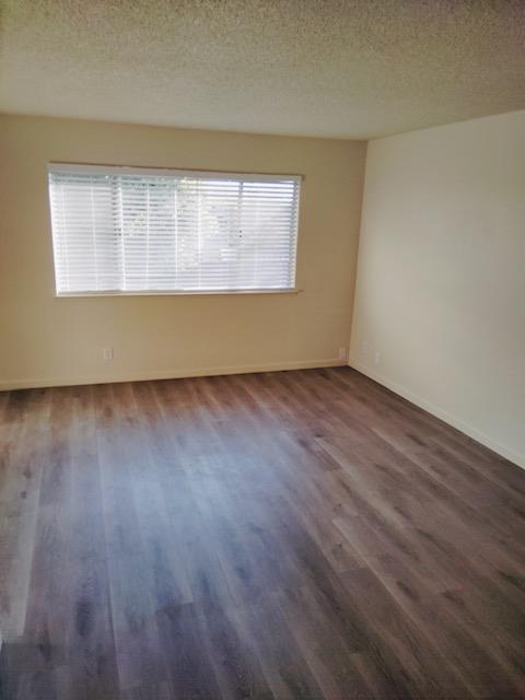 5960 Walerga Road, Unit 4 Sacramento, CA 95842 - Photo 3 of 9 an empty room with wooden floor and windows