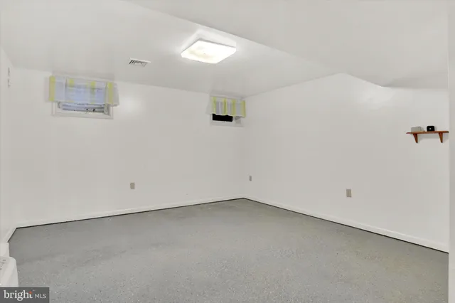 a view of an empty room with closet and a window
