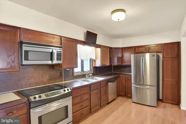 a kitchen with a refrigerator sink and cabinets