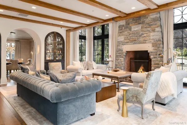 a living room with furniture fireplace and a large window