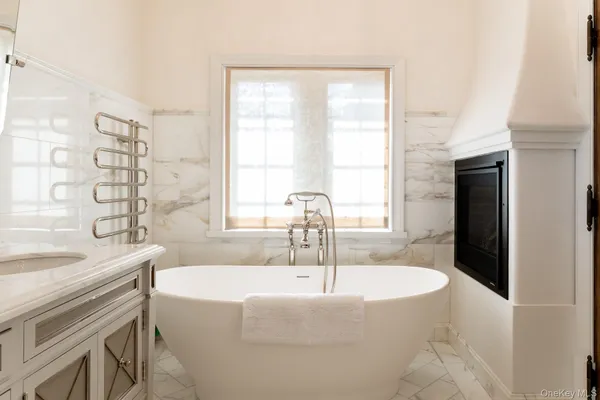 a bathroom with a granite countertop sink and a bathtub