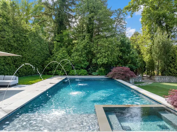 a view of backyard with seating space and trees in the background