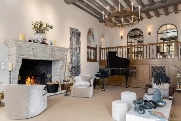 a living room with furniture a fireplace and a chandelier