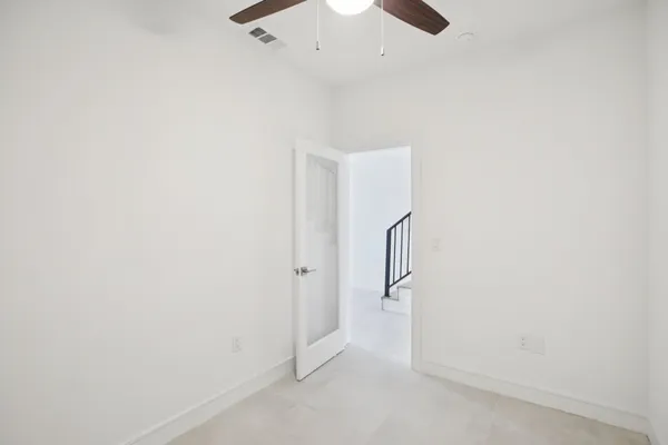 an empty room with a ceiling fan and carpet