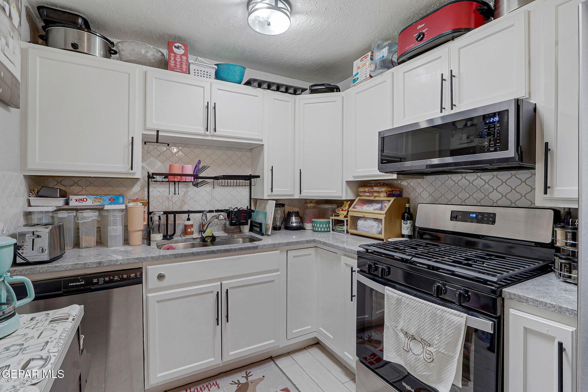 8339 White Road El Paso, TX 79907 - Photo 25 of 31 a kitchen with cabinets a sink and steel appliances