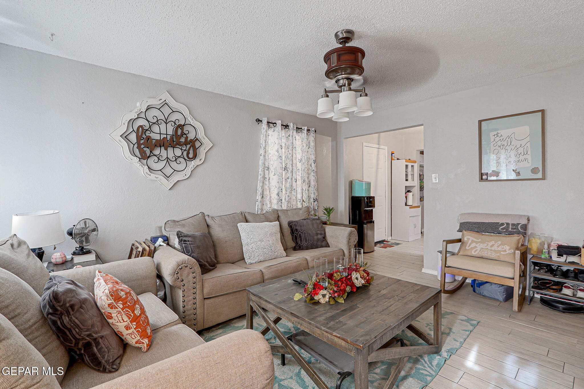 8339 White Road El Paso, TX 79907 - Photo 29 of 31 a living room with furniture a rug and a chandelier