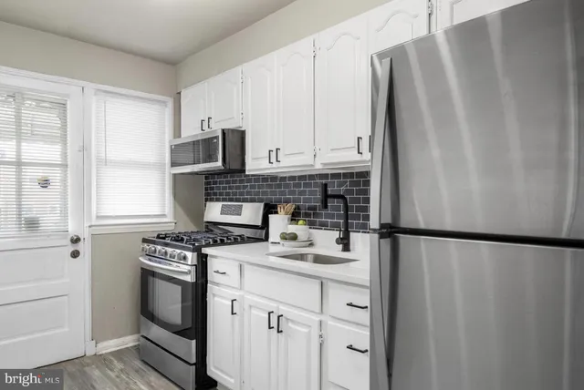 a kitchen with stainless steel appliances a refrigerator sink and cabinets