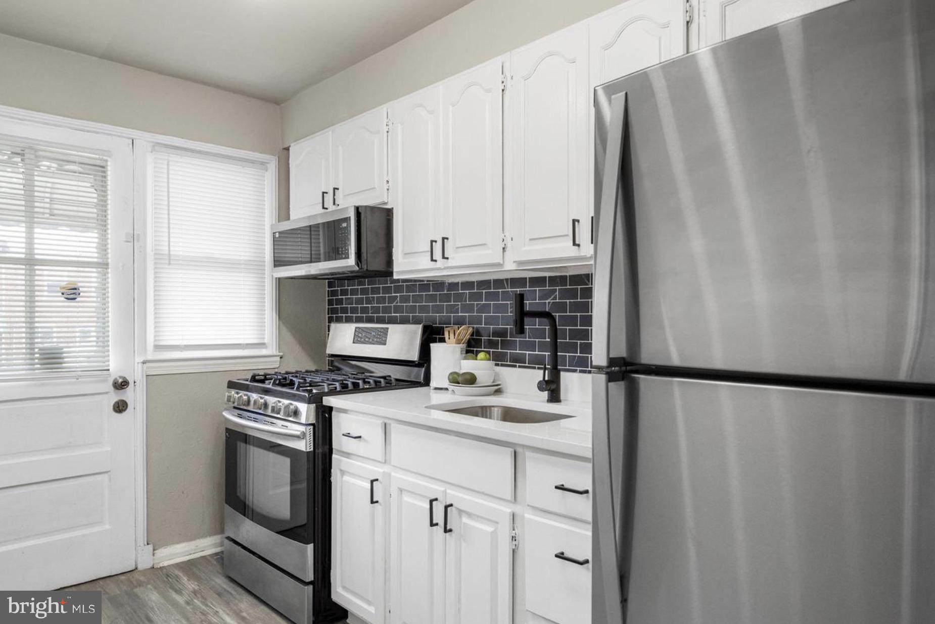 7509 Durwood Road Baltimore, MD 21222 - Photo 12 of 24 a kitchen with stainless steel appliances a refrigerator sink and cabinets