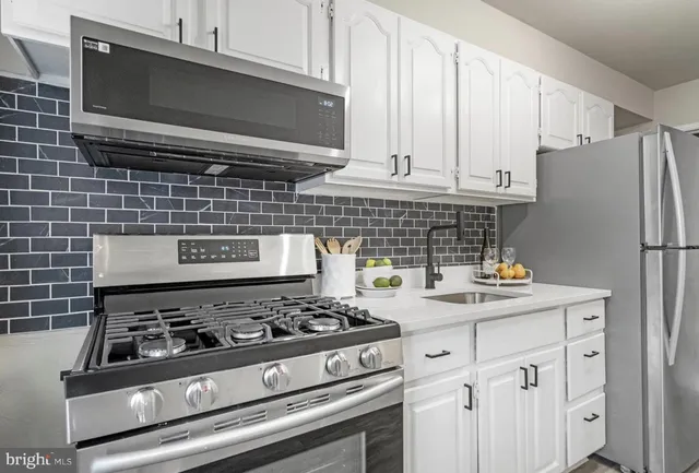 a kitchen with granite countertop a stove and a microwave