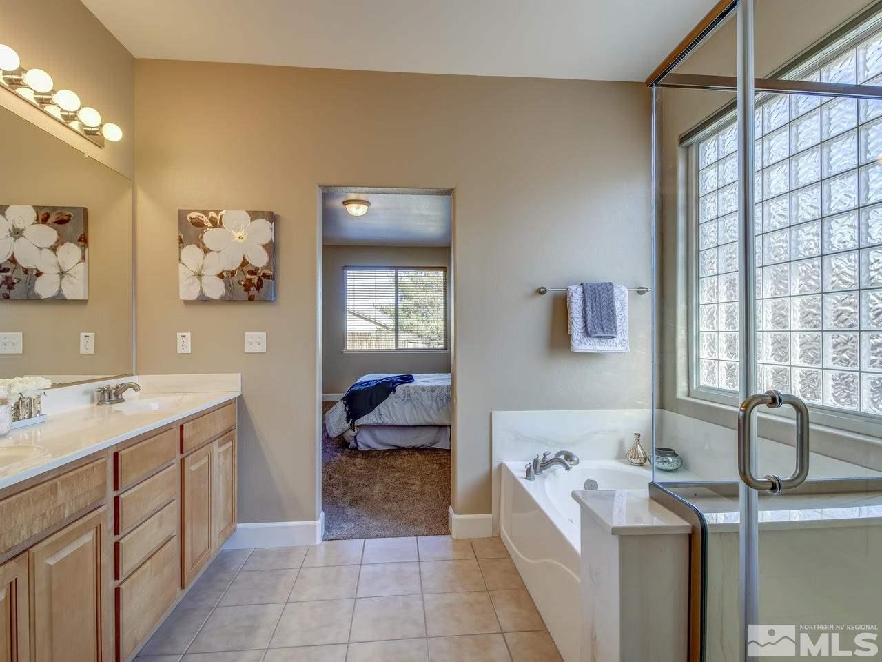 10803 Rushing Flume Drive Reno, NV 89521 - Photo 15 of 22 a spacious bathroom with a double vanity sink a mirror and a bathtub