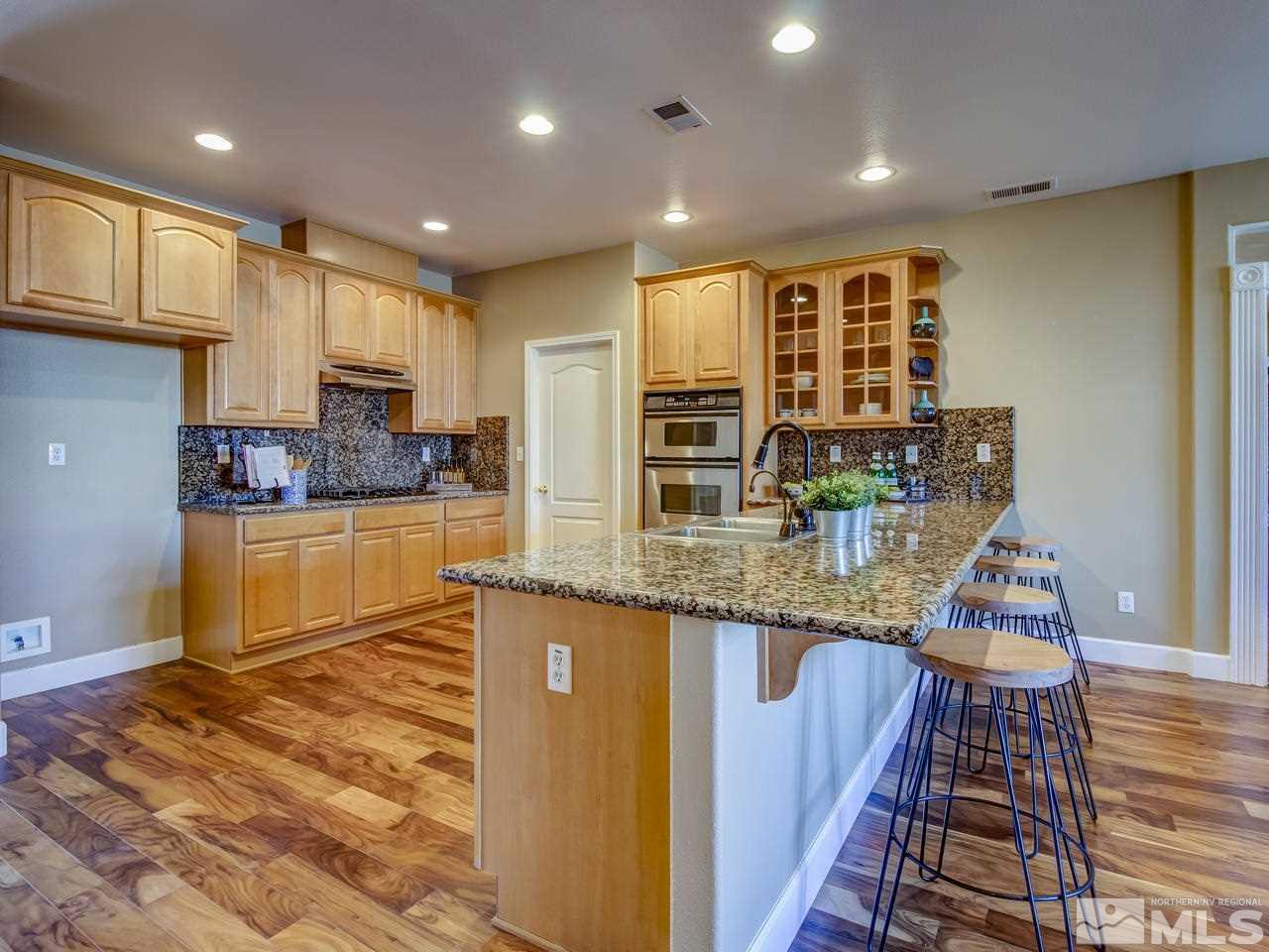 10803 Rushing Flume Drive Reno, NV 89521 - Photo 8 of 22 a kitchen with stainless steel appliances granite countertop sink stove and cabinets