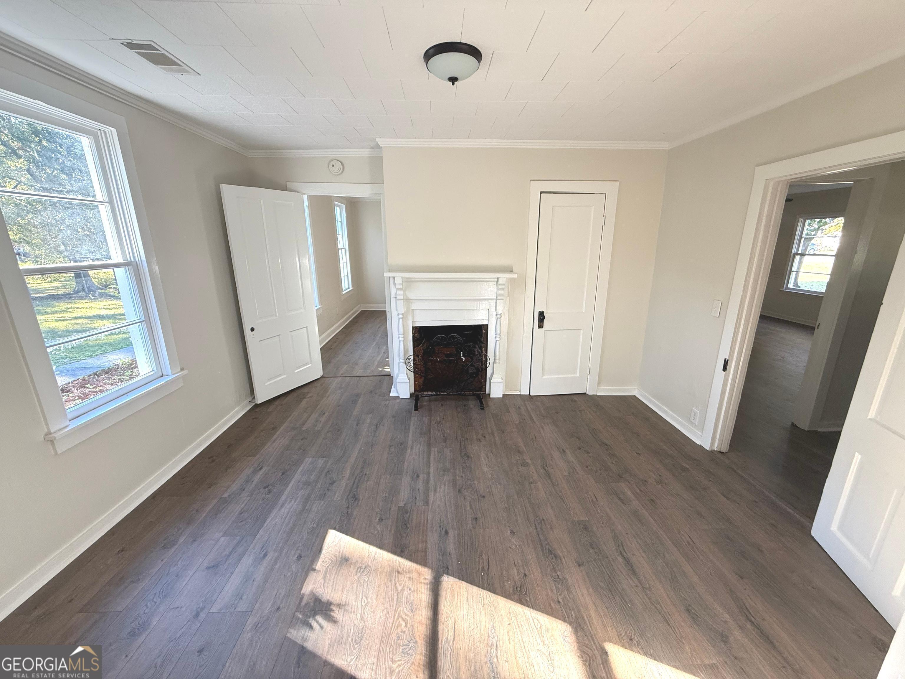 405 Monroe Street Garfield, GA 30425 - Photo 18 of 30 a view of empty room with wooden floor and fireplace