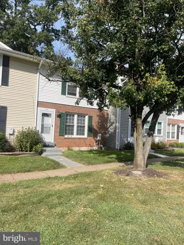a view of a yard in front of a house with a large tree