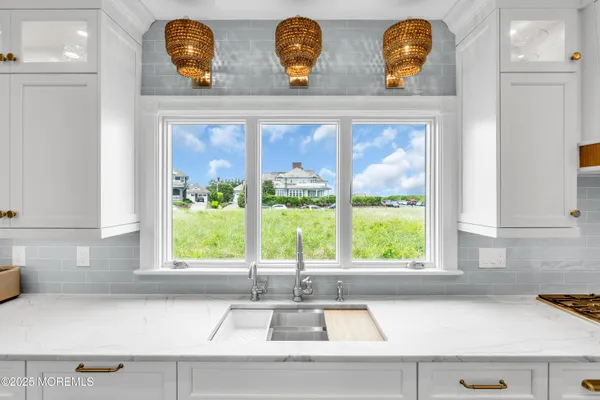 a large white kitchen with kitchen island white cabinets and stainless steel appliances