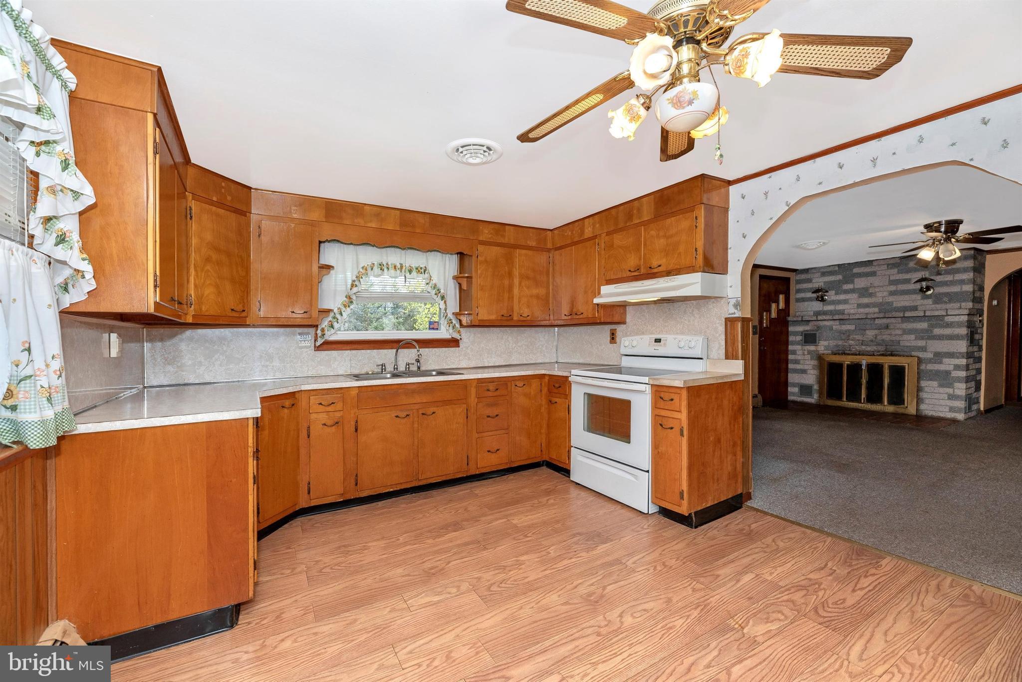 9250 Rocky Ridge Road Rocky Ridge, MD 21778 - Photo 14 of 67 a kitchen with stainless steel appliances granite countertop a stove a sink dishwasher and a fireplace with wooden floor