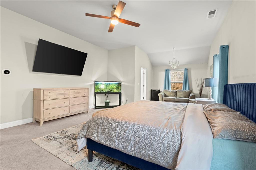 4940 Longview Run Decatur, GA 30035 - Photo 12 of 21 a spacious bedroom with a bed a flat screen tv and a chandelier