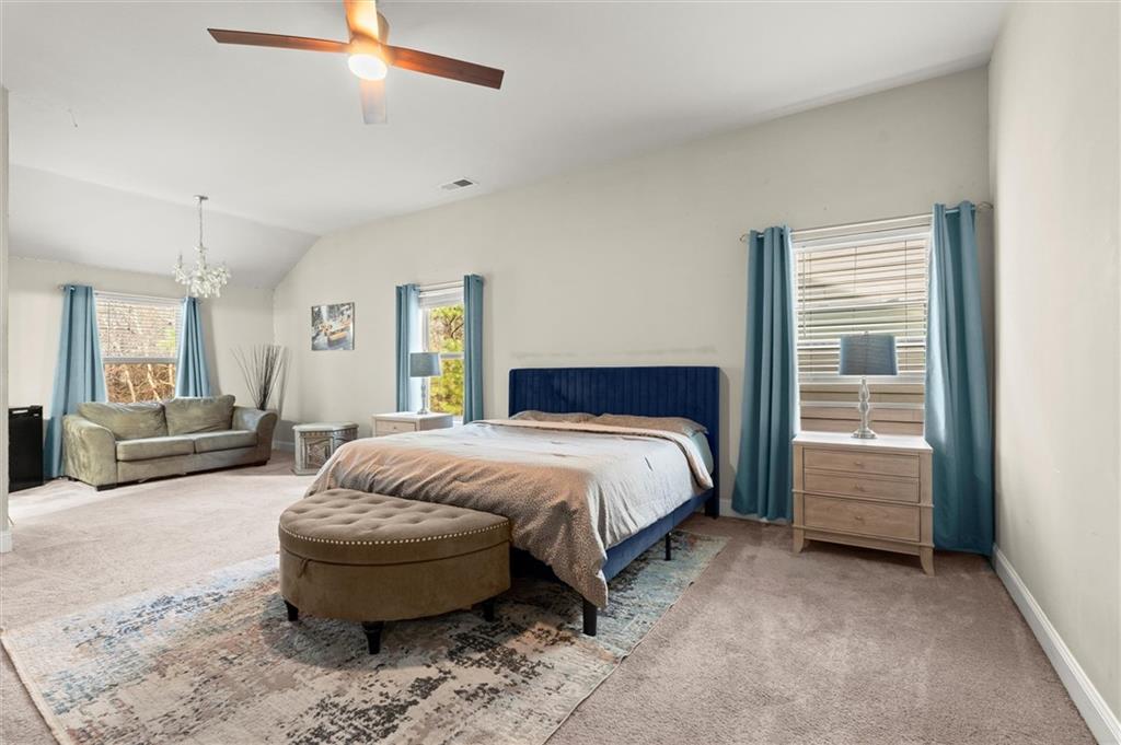 4940 Longview Run Decatur, GA 30035 - Photo 13 of 21 a spacious bedroom with a bed a couch and a chandelier
