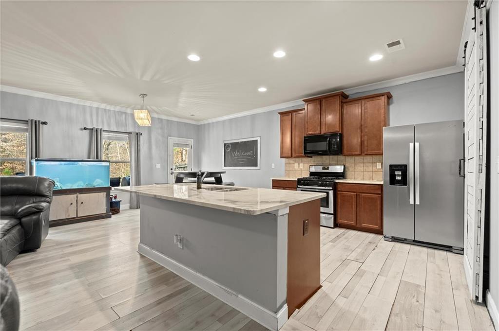 4940 Longview Run Decatur, GA 30035 - Photo 5 of 21 a kitchen with stainless steel appliances granite countertop a stove top oven a sink dishwasher a refrigerator and a dining table with wooden floor