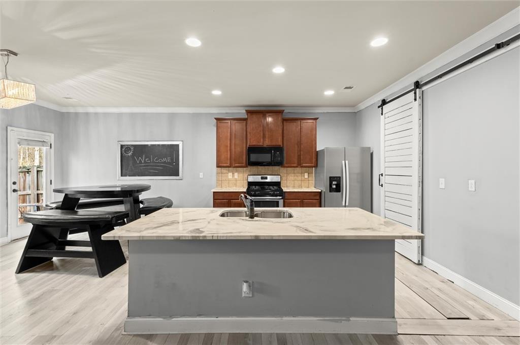 4940 Longview Run Decatur, GA 30035 - Photo 6 of 21 a kitchen with stainless steel appliances kitchen island granite countertop a sink a stove a refrigerator cabinets and chairs