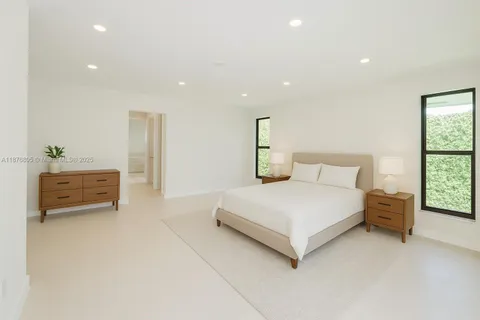 a spacious bedroom with a bed and a lamp