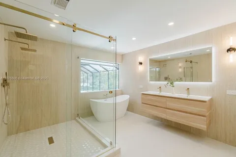 a bathroom with a tub sink shower and mirror
