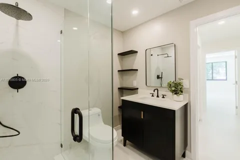 a bathroom with a sink a toilet and shower
