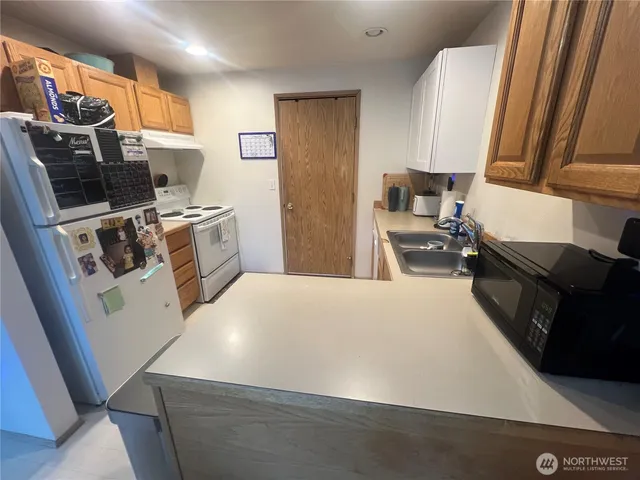 a kitchen with stainless steel appliances a stove a sink a refrigerator and cabinets