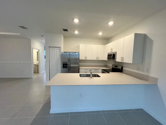 a large kitchen with stainless steel appliances a refrigerator and a stove