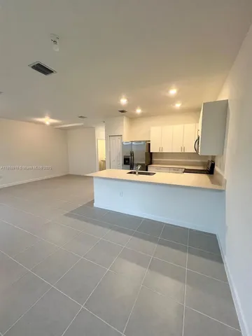 a large kitchen with kitchen island a sink stainless steel appliances and cabinets
