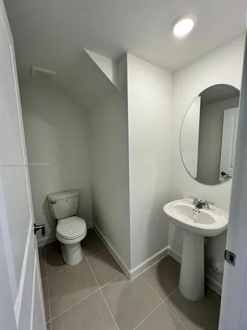 a bathroom with a sink toilet and a mirror