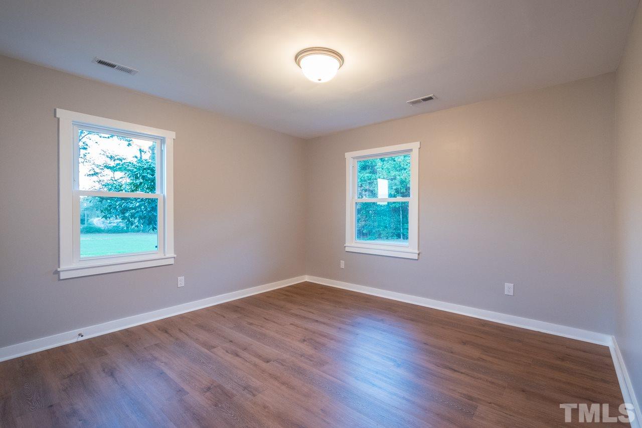 166 Hannah Creek Road Four Oaks, NC 27524 - Photo 12 of 20 an empty room with wooden floor and windows