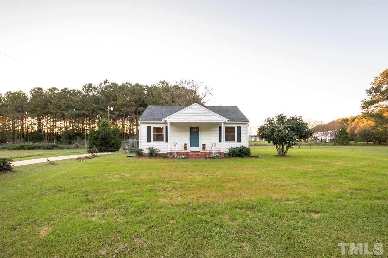 166 Hannah Creek Road Four Oaks, NC 27524 - Photo 20 of 20 a front view of a house with a garden and lake view