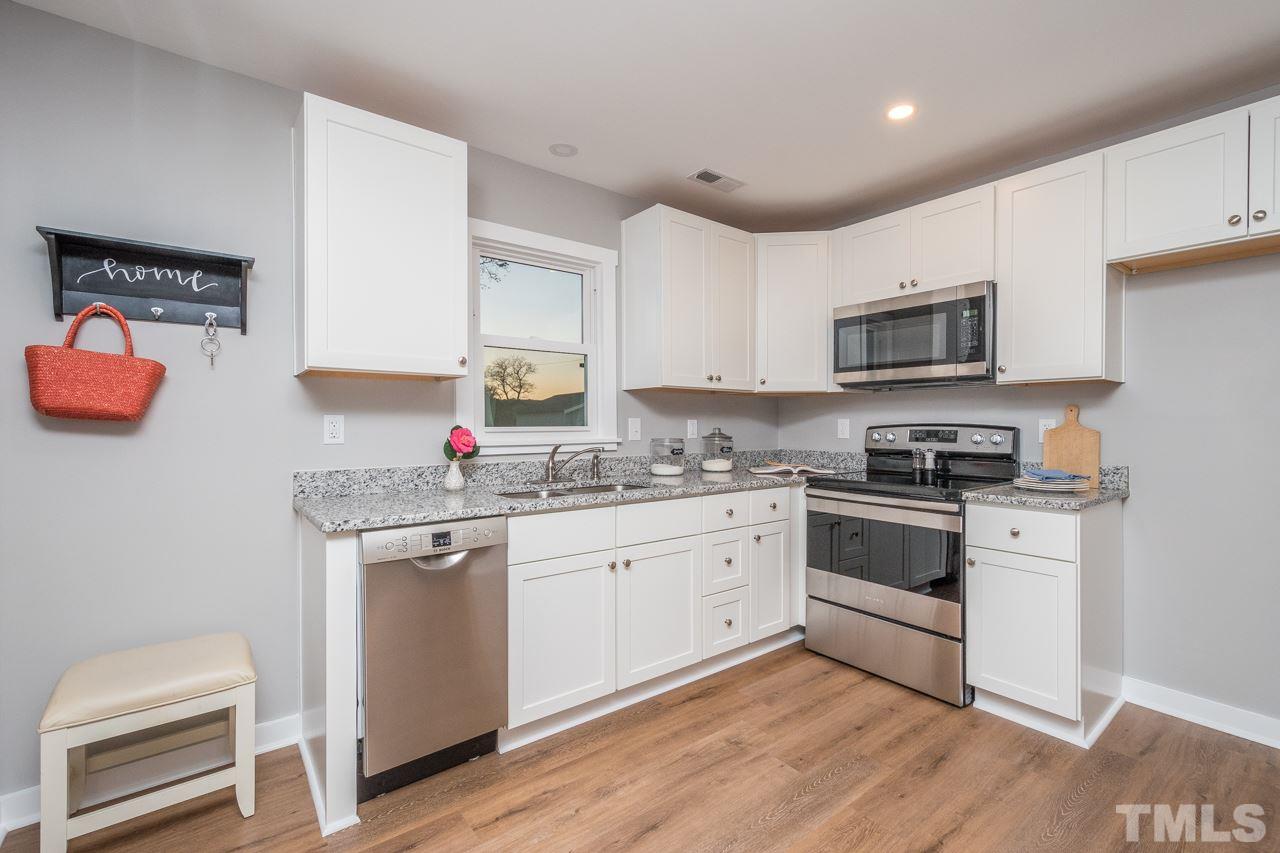 166 Hannah Creek Road Four Oaks, NC 27524 - Photo 5 of 20 a kitchen with stainless steel appliances granite countertop a stove top oven a sink dishwasher and a refrigerator with wooden floor