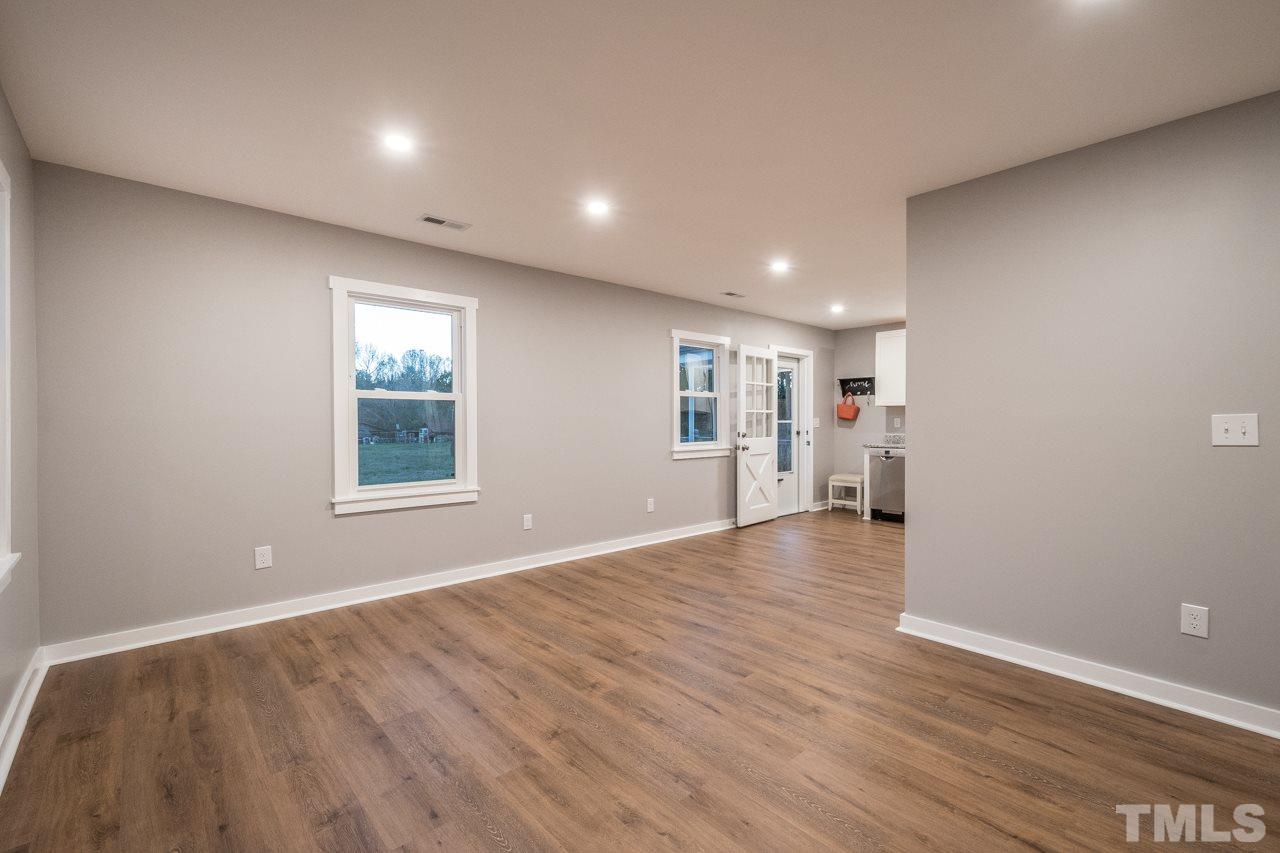 166 Hannah Creek Road Four Oaks, NC 27524 - Photo 8 of 20 a view of an empty room with wooden floor and a window