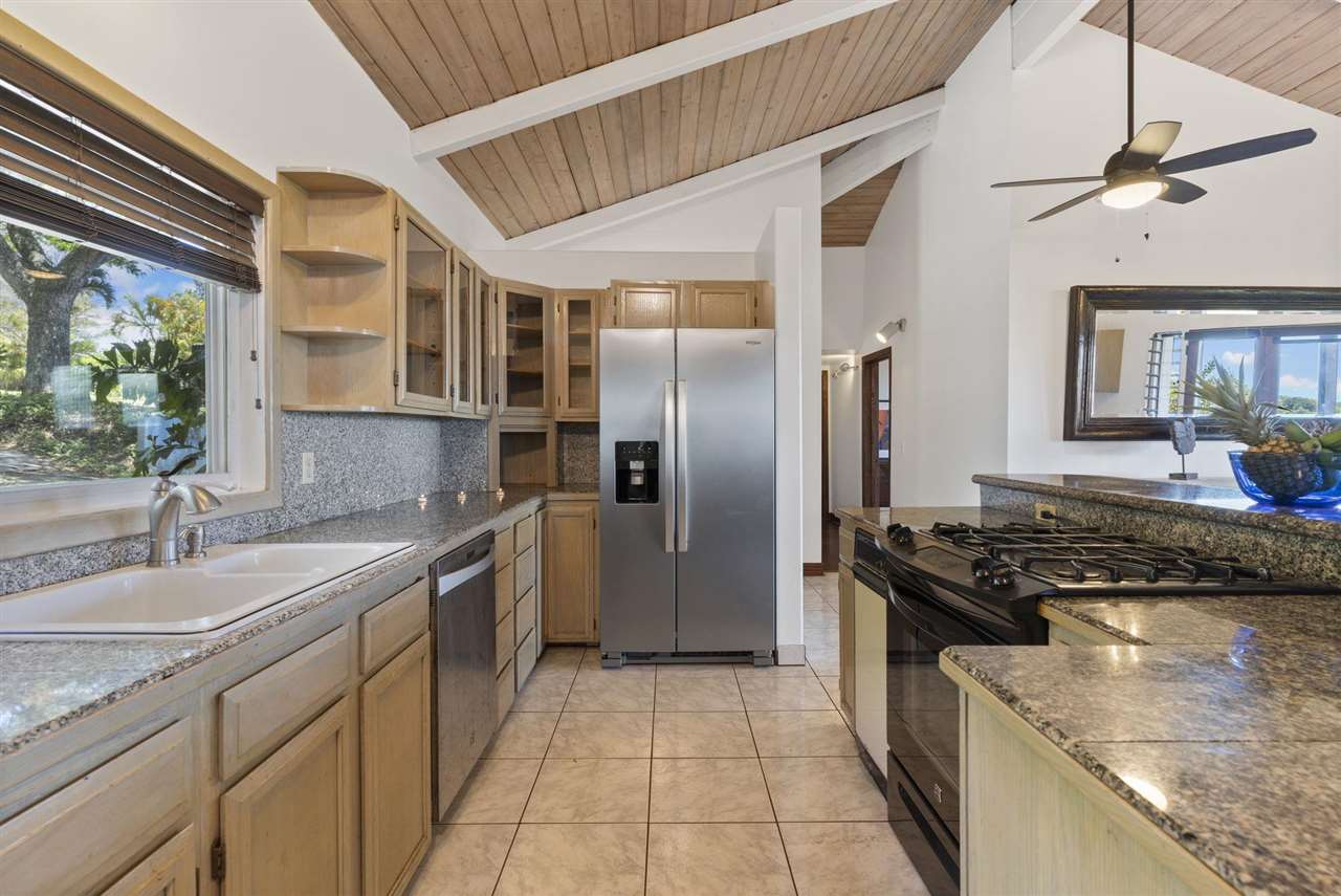 2560 Kokomo Road Haiku, HI 96708 - Photo 16 of 30 a kitchen with stainless steel appliances granite countertop a sink stove and refrigerator