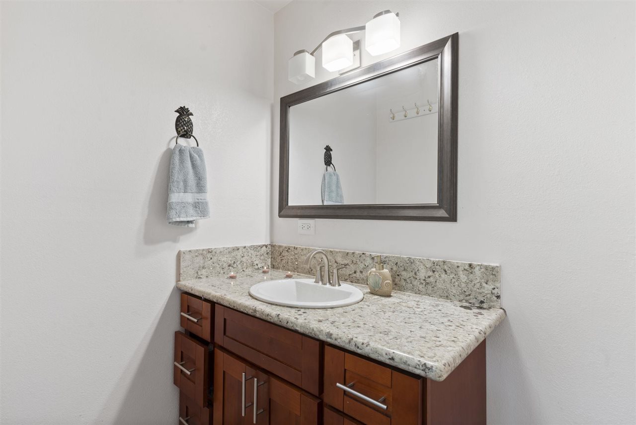 2560 Kokomo Road Haiku, HI 96708 - Photo 21 of 30 a bathroom with a granite countertop sink and a mirror