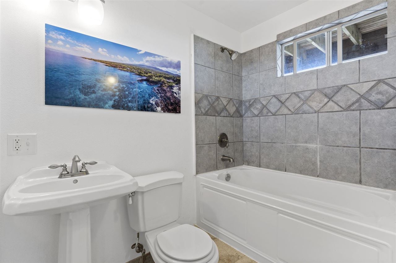 2560 Kokomo Road Haiku, HI 96708 - Photo 23 of 30 a bathroom with a sink a mirror bathtub and toilet