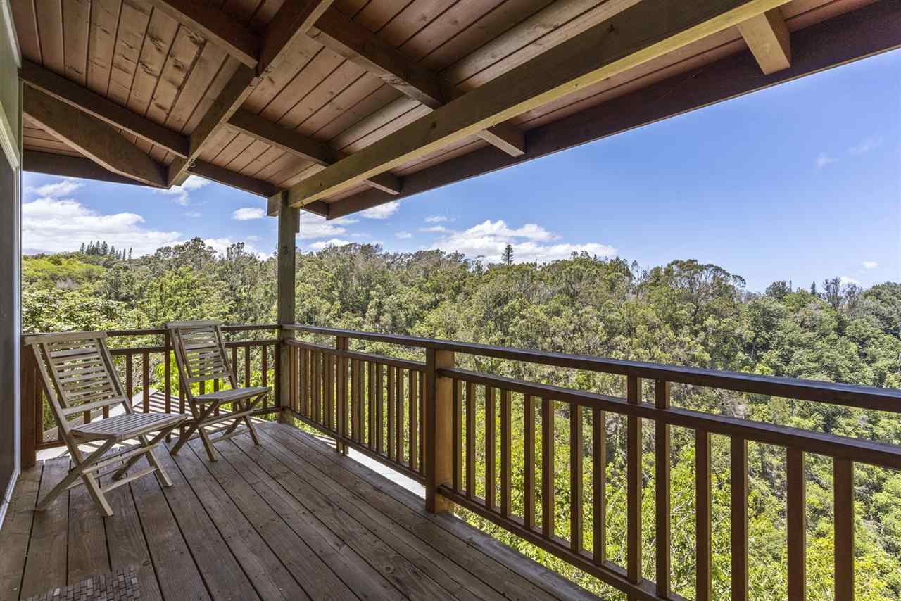 2560 Kokomo Road Haiku, HI 96708 - Photo 24 of 30 a view of a balcony with chairs and wooden floor
