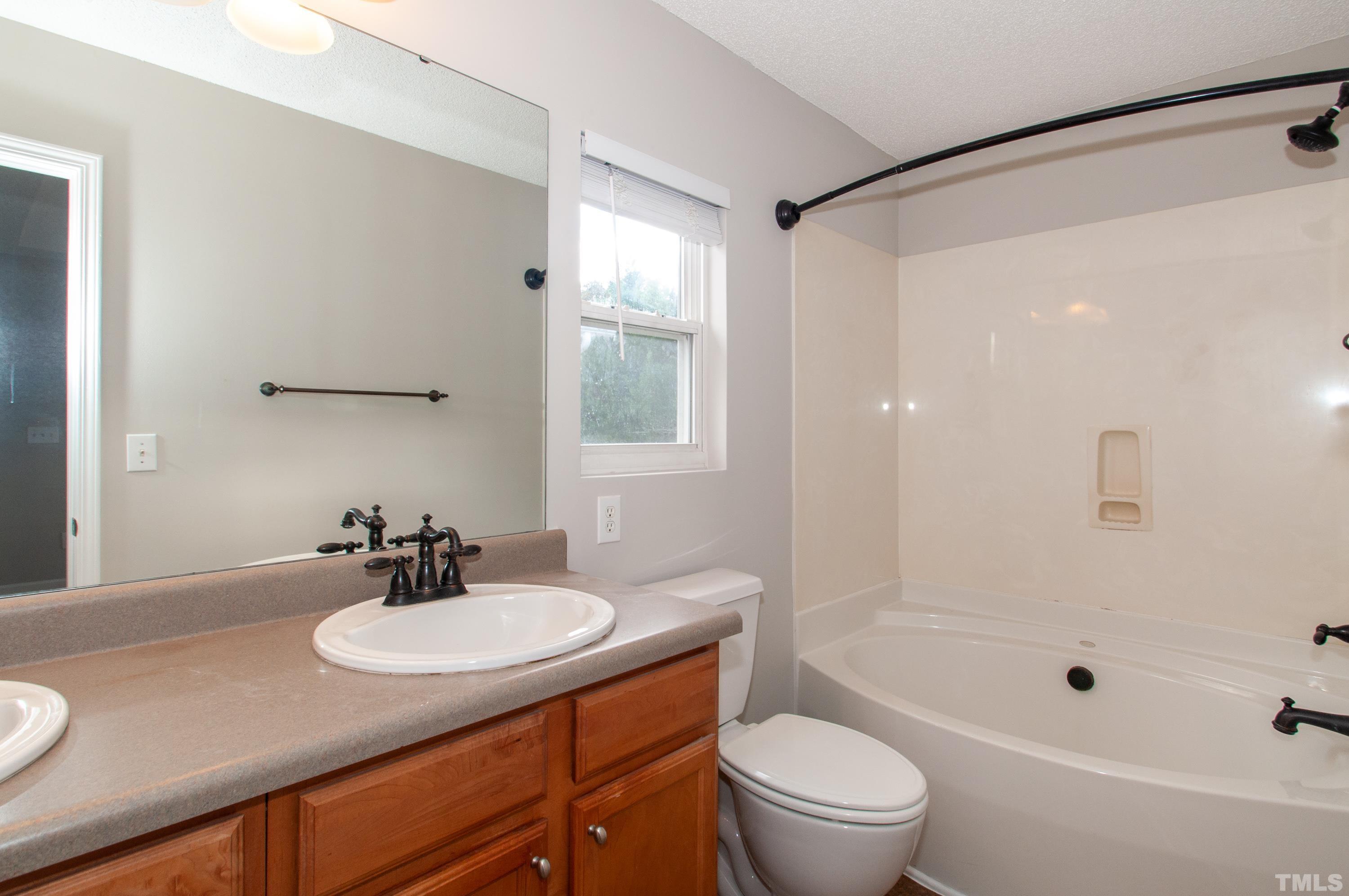 3808 Tryon Ridge Drive Raleigh, NC 27610 - Photo 12 of 30 a bathroom with a sink toilet a mirror and shower